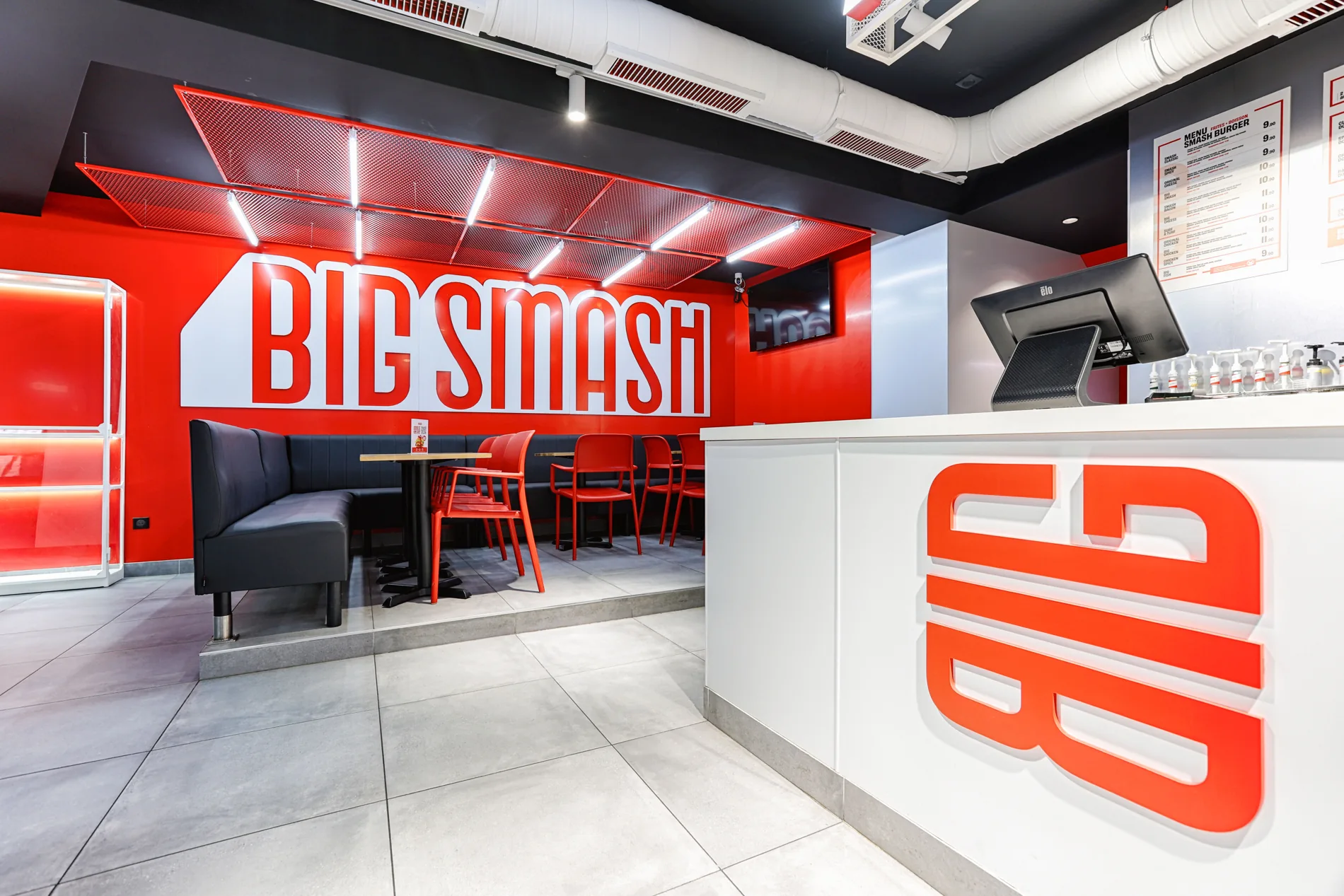 BIG SMASH Paris 18 livré : salle rouge, tables et comptoir blanc